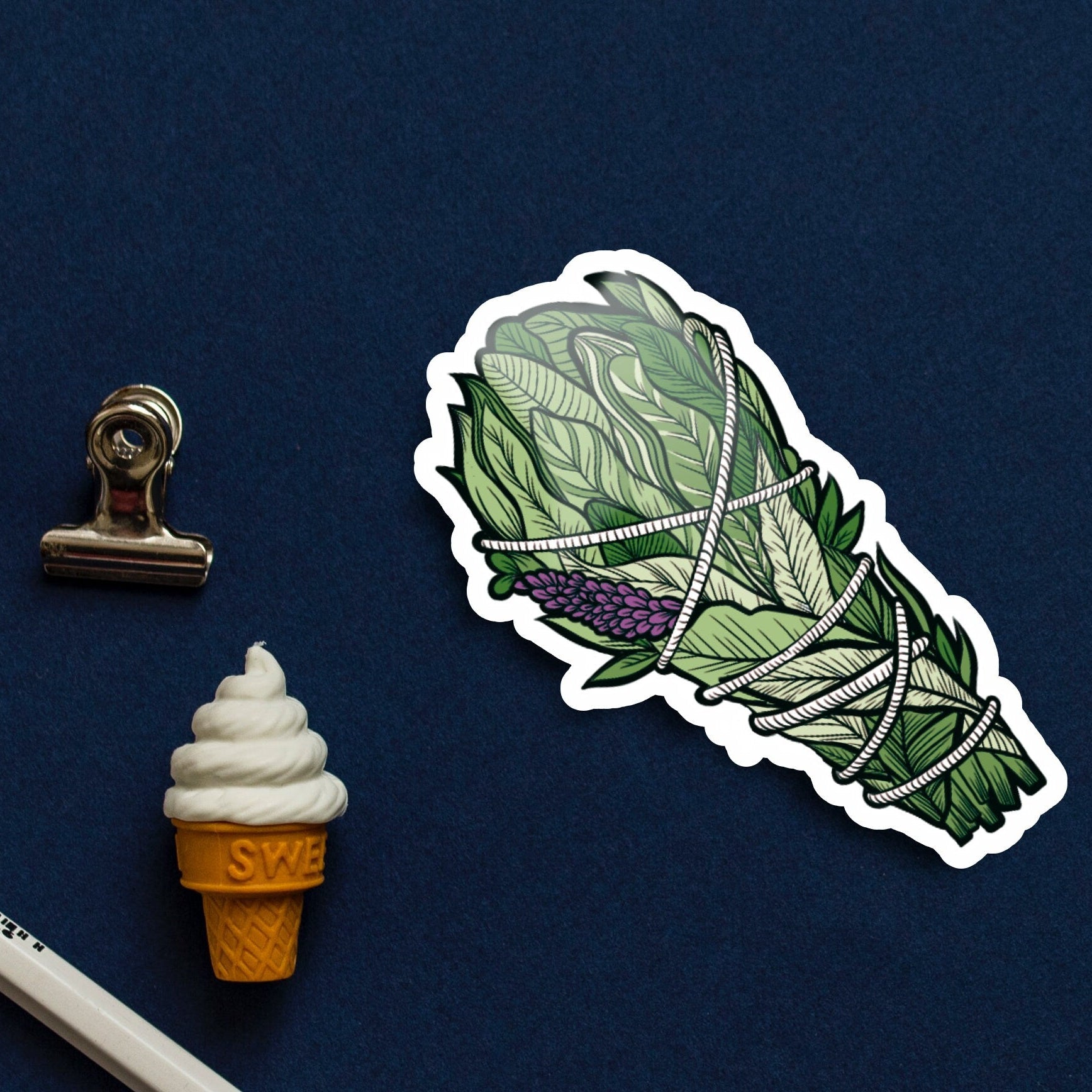 Sticker of a leafy bundle on a blue background with stationery items.
